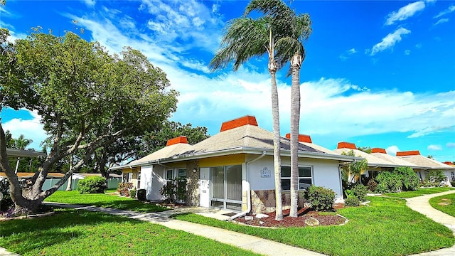 4359 Tahitian Gardens Cir Unit A, Holiday, FL 34691 - view of side of home with a lawn, stucco siding, and a chimney