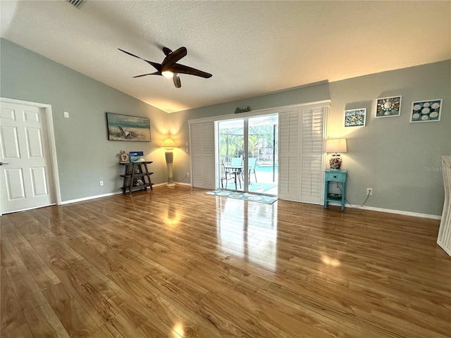 713 Rustic Oaks Dr, Palm Harbor, FL 34684 - unfurnished living room with lofted ceiling, a ceiling fan, wood finished floors, and a textured ceiling
