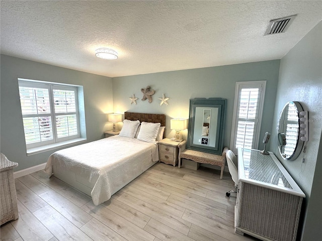 713 Rustic Oaks Dr, Palm Harbor, FL 34684 - bedroom featuring a textured ceiling, multiple windows, and light wood finished floors