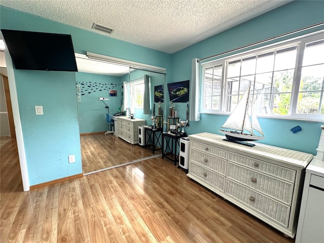 713 Rustic Oaks Dr, Palm Harbor, FL 34684 - bedroom featuring wood finished floors, a closet, and a textured ceiling