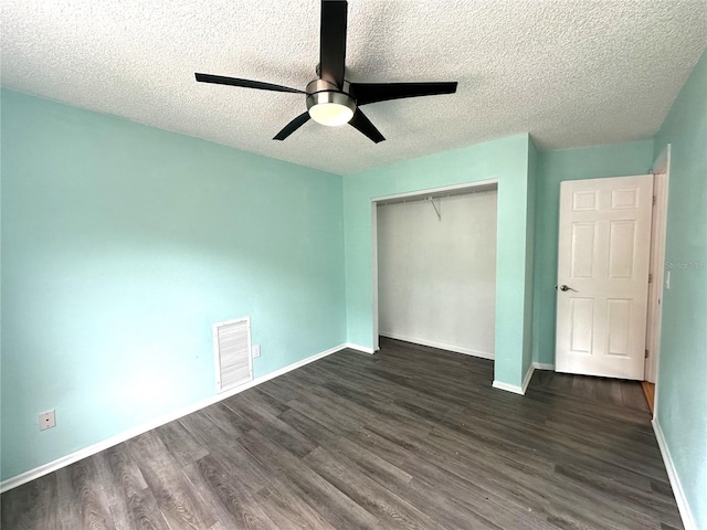 713 Rustic Oaks Dr, Palm Harbor, FL 34684 - unfurnished bedroom featuring dark wood finished floors, a closet, a textured ceiling, and a ceiling fan