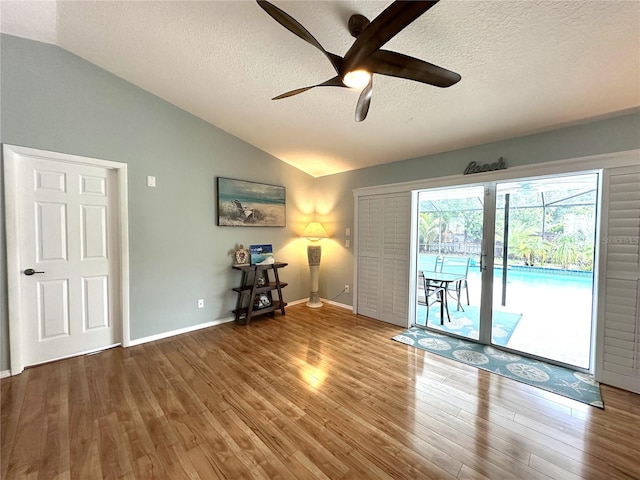 713 Rustic Oaks Dr, Palm Harbor, FL 34684 - unfurnished room featuring vaulted ceiling, ceiling fan, wood finished floors, and a textured ceiling