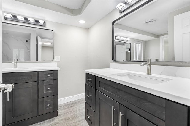 7607 New York Ave, Hudson, FL 34667 - bathroom with two vanities, wood finished floors, a shower, and recessed lighting