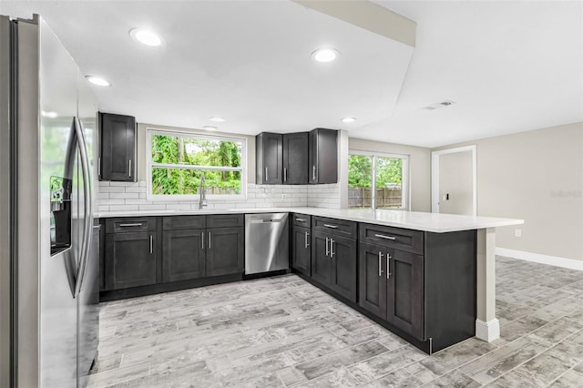 7607 New York Ave, Hudson, FL 34667 - kitchen featuring stainless steel appliances, a peninsula, light countertops, decorative backsplash, and recessed lighting