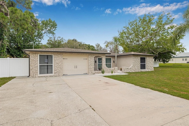 7607 New York Ave, Hudson, FL 34667 - ranch-style home with stone siding, an attached garage, and driveway