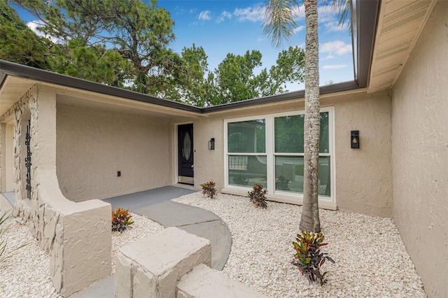 7607 New York Ave, Hudson, FL 34667 - view of exterior entry with stucco siding and a patio
