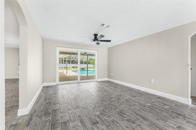 7607 New York Ave, Hudson, FL 34667 - spare room featuring arched walkways, wood finished floors, and a ceiling fan