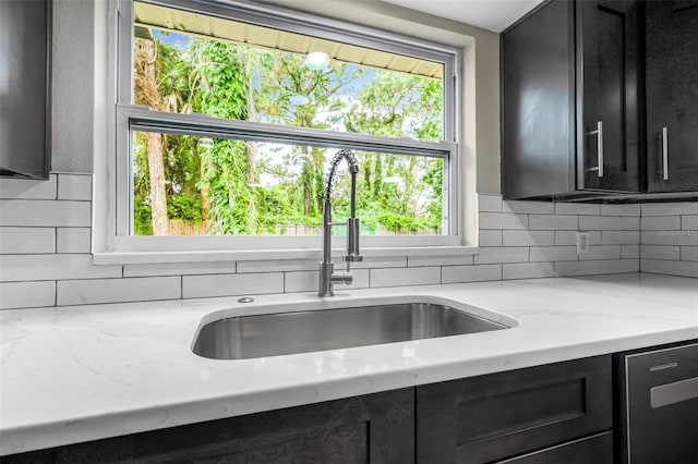 7607 New York Ave, Hudson, FL 34667 - kitchen featuring dark cabinets, stainless steel dishwasher, tasteful backsplash, and light stone countertops