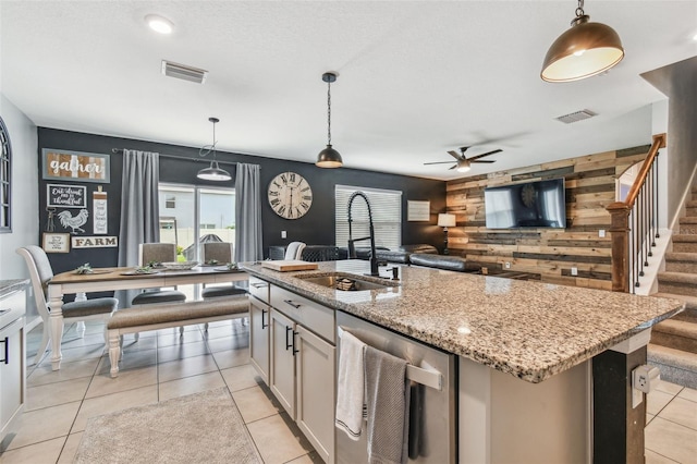 33678 Jasper Stone Dr, Wesley Chapel, FL 33543 - kitchen with stainless steel dishwasher, ceiling fan, wooden walls, pendant lighting, and an accent wall