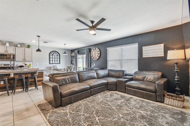 33678 Jasper Stone Dr, Wesley Chapel, FL 33543 - living area with a ceiling fan, light tile patterned floors, and a textured ceiling