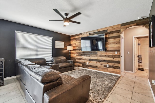 33678 Jasper Stone Dr, Wesley Chapel, FL 33543 - living area with wooden walls, a ceiling fan, arched walkways, light tile patterned flooring, and an accent wall