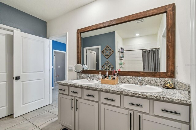 33678 Jasper Stone Dr, Wesley Chapel, FL 33543 - bathroom with double vanity, tile patterned floors, and tiled shower