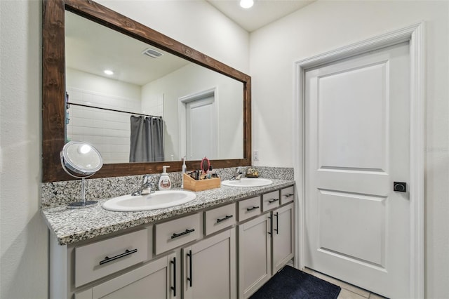 33678 Jasper Stone Dr, Wesley Chapel, FL 33543 - bathroom featuring double vanity, a tile shower, and tile patterned flooring