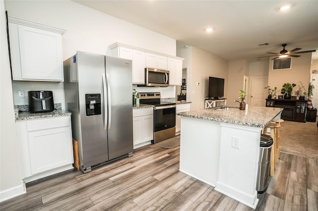 35210 Daisy Meadow Loop, Zephyrhills, FL 33541 - kitchen with stainless steel appliances, light wood-type flooring, ceiling fan, white cabinetry, and recessed lighting