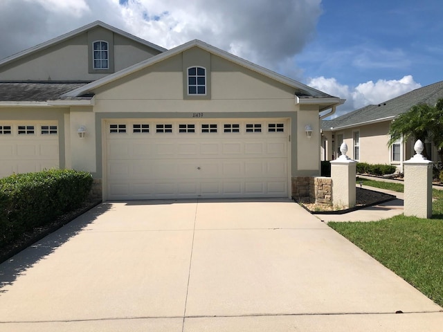 11439 Cambray Creek Loop, Riverview, FL 33579 - view of front of property with stucco siding, stone siding, concrete driveway, and a garage