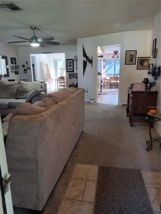 7307 Windsor Mill Rd, Hudson, FL 34667 - living room with a ceiling fan, a textured ceiling, light colored carpet, and light tile patterned floors