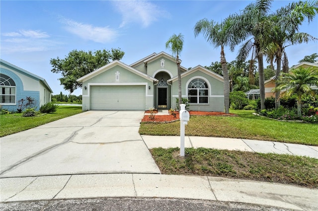 1725 Bondurant Way, Brandon, FL 33511 - view of front of home with a garage, stucco siding, driveway, and a front lawn