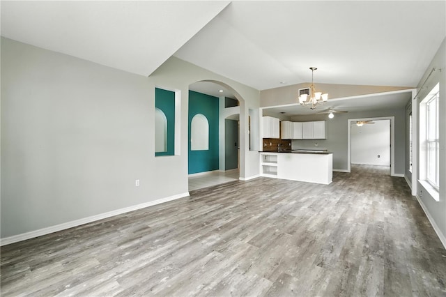 1725 Bondurant Way, Brandon, FL 33511 - unfurnished living room with a chandelier, vaulted ceiling, wood finished floors, and arched walkways