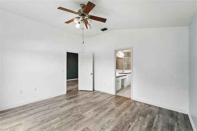 1725 Bondurant Way, Brandon, FL 33511 - unfurnished bedroom featuring light wood finished floors, lofted ceiling, ensuite bathroom, and ceiling fan