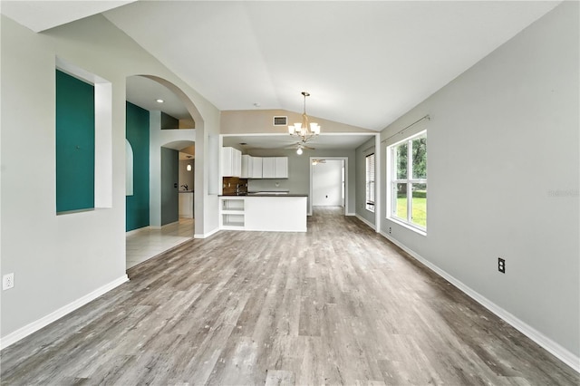 1725 Bondurant Way, Brandon, FL 33511 - unfurnished living room with lofted ceiling, a chandelier, wood finished floors, and arched walkways