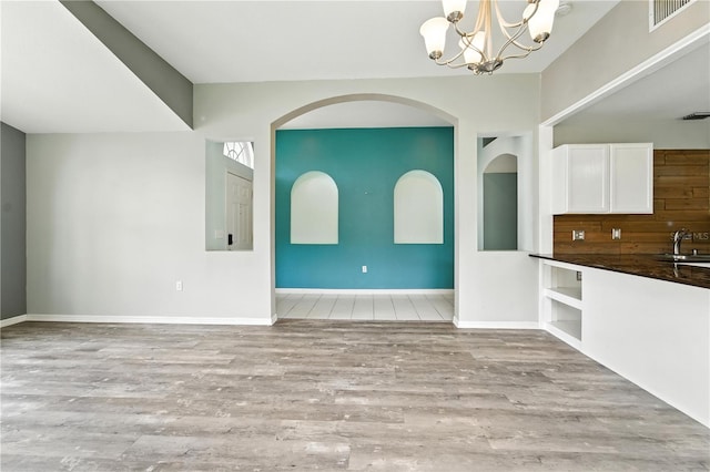 1725 Bondurant Way, Brandon, FL 33511 - unfurnished dining area with wood finished floors, a chandelier, and arched walkways