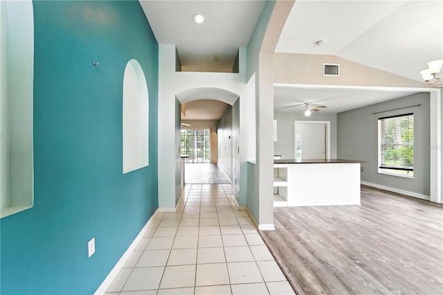 1725 Bondurant Way, Brandon, FL 33511 - hallway with healthy amount of natural light, arched walkways, lofted ceiling, and light wood-type flooring