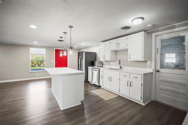 1018 Osprey Ct, Dunedin, FL 34698 - kitchen with appliances with stainless steel finishes, dark wood-style flooring, a textured ceiling, white cabinets, and light countertops