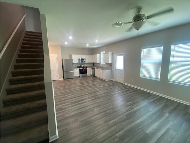 35233 White Water Lily Way, Zephyrhills, FL 33541 - unfurnished living room featuring a ceiling fan, stairs, dark wood finished floors, and recessed lighting