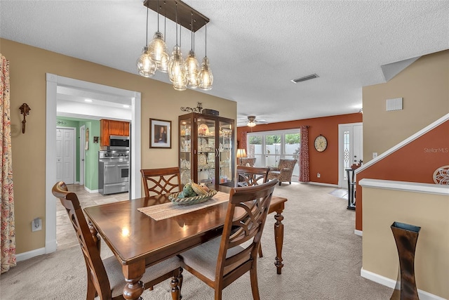 617 Valley Hill Dr, Brandon, FL 33510 - dining area with light carpet, a textured ceiling, a ceiling fan, and a chandelier