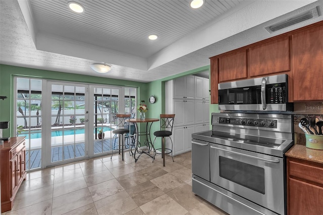 617 Valley Hill Dr, Brandon, FL 33510 - kitchen featuring appliances with stainless steel finishes, a raised ceiling, french doors, recessed lighting, and brown cabinetry