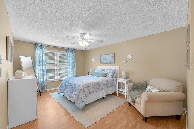 617 Valley Hill Dr, Brandon, FL 33510 - bedroom with light wood finished floors, a textured ceiling, and a ceiling fan