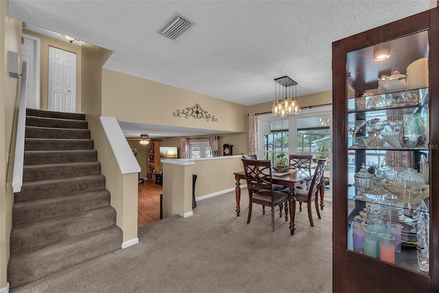 617 Valley Hill Dr, Brandon, FL 33510 - dining area featuring stairs, carpet, a chandelier, a textured ceiling, and a ceiling fan