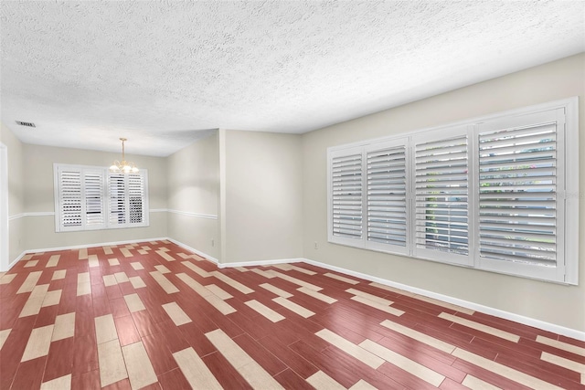 3840 Rolling Cir, Valrico, FL 33594 - spare room with a chandelier, a textured ceiling, healthy amount of natural light, and wood finished floors