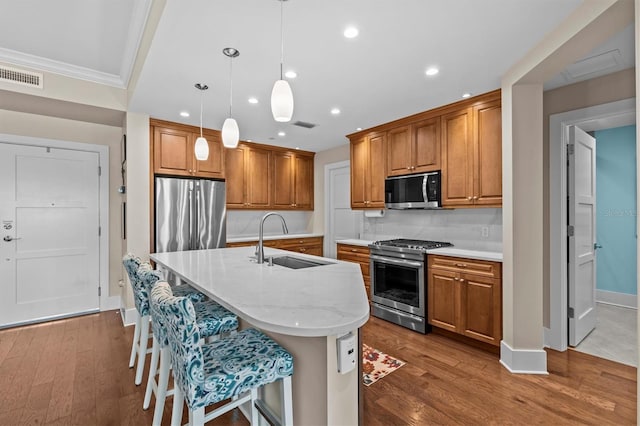 200 Main St Unit 204, Dunedin, FL 34698 - kitchen with appliances with stainless steel finishes, brown cabinets, dark wood-type flooring, recessed lighting, and an island with sink