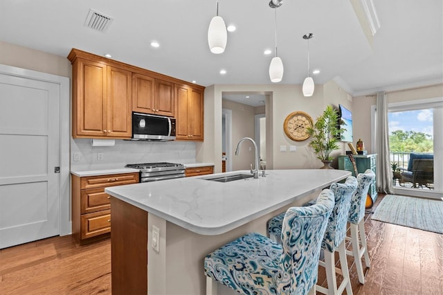 200 Main St Unit 204, Dunedin, FL 34698 - kitchen with appliances with stainless steel finishes, light wood-type flooring, a center island with sink, a kitchen breakfast bar, and recessed lighting
