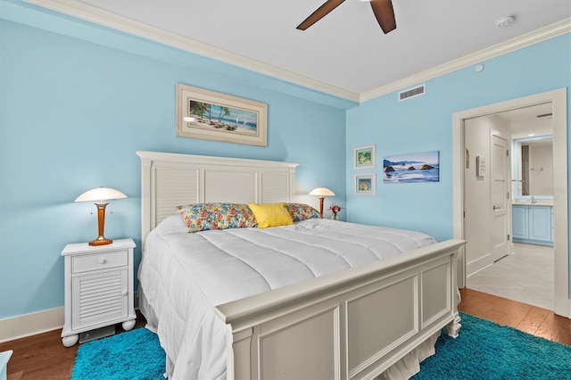 200 Main St Unit 204, Dunedin, FL 34698 - bedroom featuring ornamental molding, wood finished floors, ensuite bath, and a ceiling fan