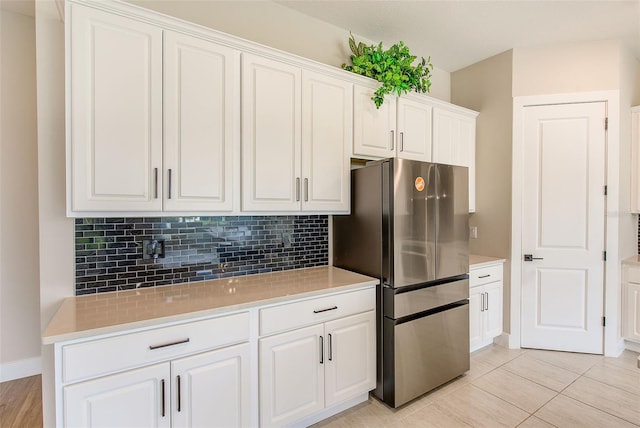 8717 Sanders Tree Loop, Wesley Chapel, FL 33545 - kitchen featuring freestanding refrigerator, tasteful backsplash, light countertops, white cabinetry, and light tile patterned floors