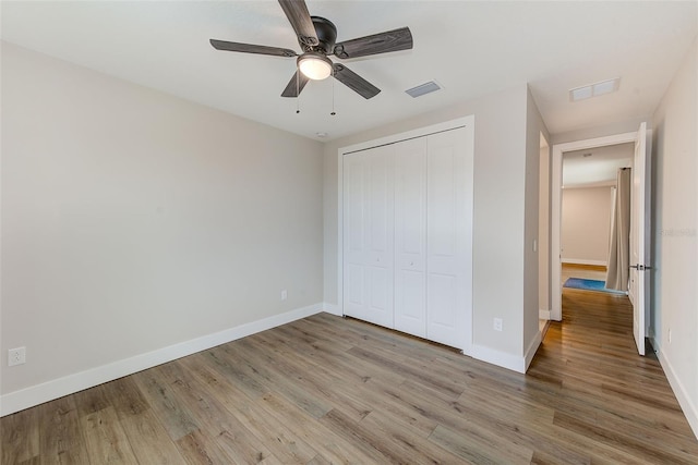 8717 Sanders Tree Loop, Wesley Chapel, FL 33545 - unfurnished bedroom with light wood-style flooring, a closet, and ceiling fan