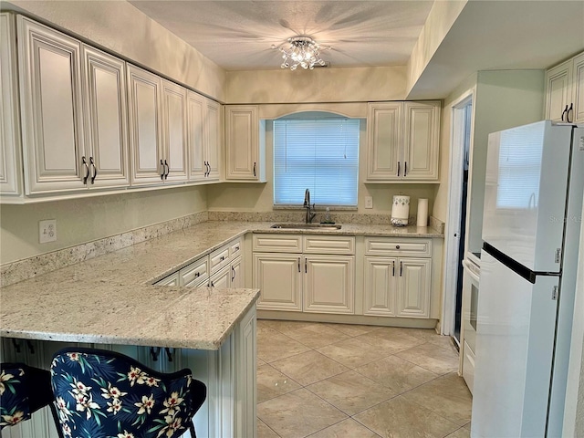 7026 20th St N, Saint Petersburg, FL 33702 - kitchen featuring freestanding refrigerator, light tile patterned floors, and light stone counters