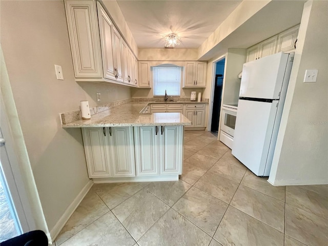 7026 20th St N, Saint Petersburg, FL 33702 - kitchen featuring freestanding refrigerator, a peninsula, stove, and light tile patterned floors
