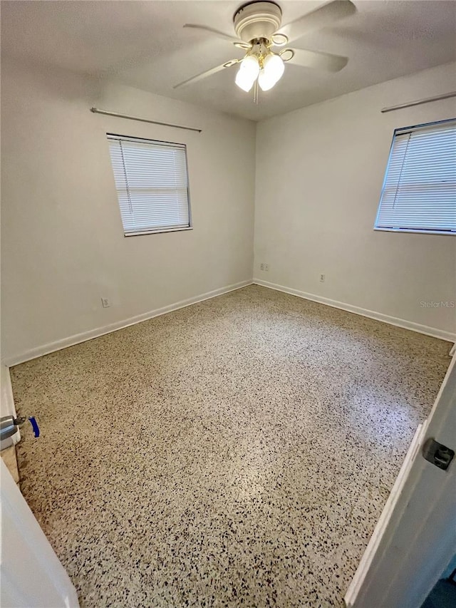 7026 20th St N, Saint Petersburg, FL 33702 - unfurnished room with speckle patterned floor, ceiling fan, and plenty of natural light