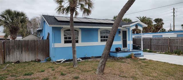 7623 Gulf Blvd, St Pete Beach, FL 33706 - view of side of property featuring roof mounted solar panels, stucco siding, and a shingled roof