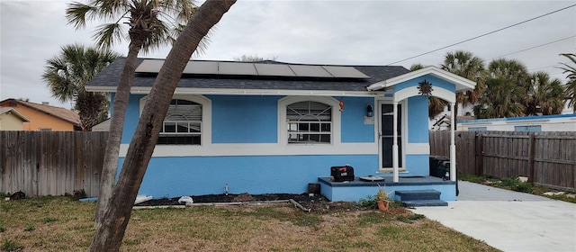 7623 Gulf Blvd, St Pete Beach, FL 33706 - view of front of home featuring solar panels, stucco siding, and roof with shingles