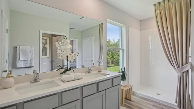 2615 Hardin Way, Zephyrhills, FL 33541 - full bath featuring a shower with curtain, double vanity, and wood finished floors