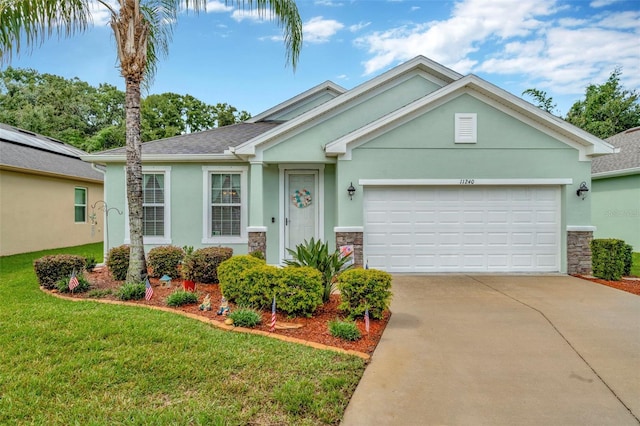 11240 Merganser Way, New Port Richey, FL 34654 - single story home with stone siding, stucco siding, concrete driveway, an attached garage, and a front yard