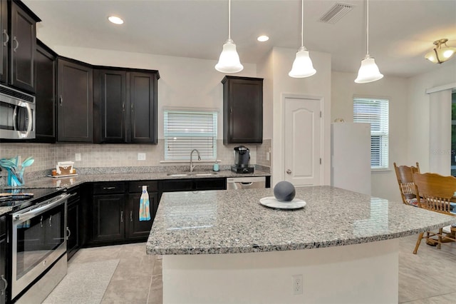 11240 Merganser Way, New Port Richey, FL 34654 - kitchen with appliances with stainless steel finishes, light tile patterned floors, backsplash, light stone countertops, and recessed lighting