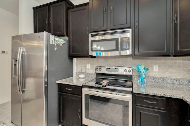 11240 Merganser Way, New Port Richey, FL 34654 - kitchen featuring stainless steel appliances, backsplash, light stone countertops, and light tile patterned floors