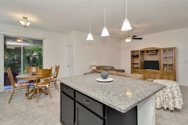 11240 Merganser Way, New Port Richey, FL 34654 - kitchen with ceiling fan, light stone countertops, decorative light fixtures, and a kitchen island