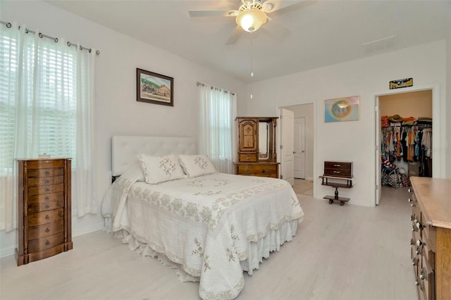 11240 Merganser Way, New Port Richey, FL 34654 - bedroom featuring light wood-style flooring, multiple windows, and a walk in closet
