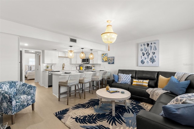 10280 Gulf Blvd Unit 12, Treasure Island, FL 33706 - living area featuring light wood-style flooring and a chandelier